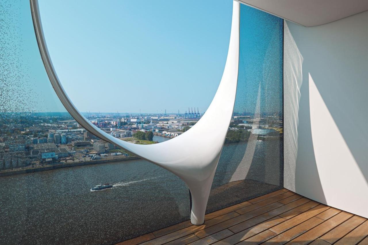 더 웨스틴 함부르크 함브루크 외부 사진 The photo showcases a modern architectural interior featuring a large, uniquely designed window that creates a dramatic visual effect. The window has an organic, flowing shape, resembling a sculptural element, and is made of glass that allows natural