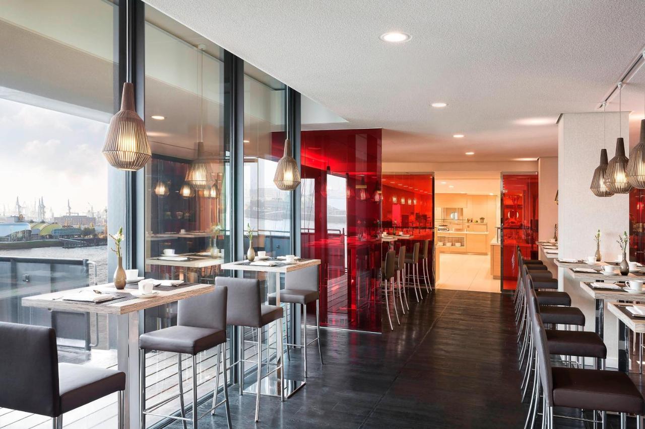 더 웨스틴 함부르크 함브루크 외부 사진 The photo showcases a modern restaurant interior characterized by sleek design and contemporary decor. The space features a combination of large windows allowing natural light to filter in, creating an open and airy atmosphere. The walls are accented